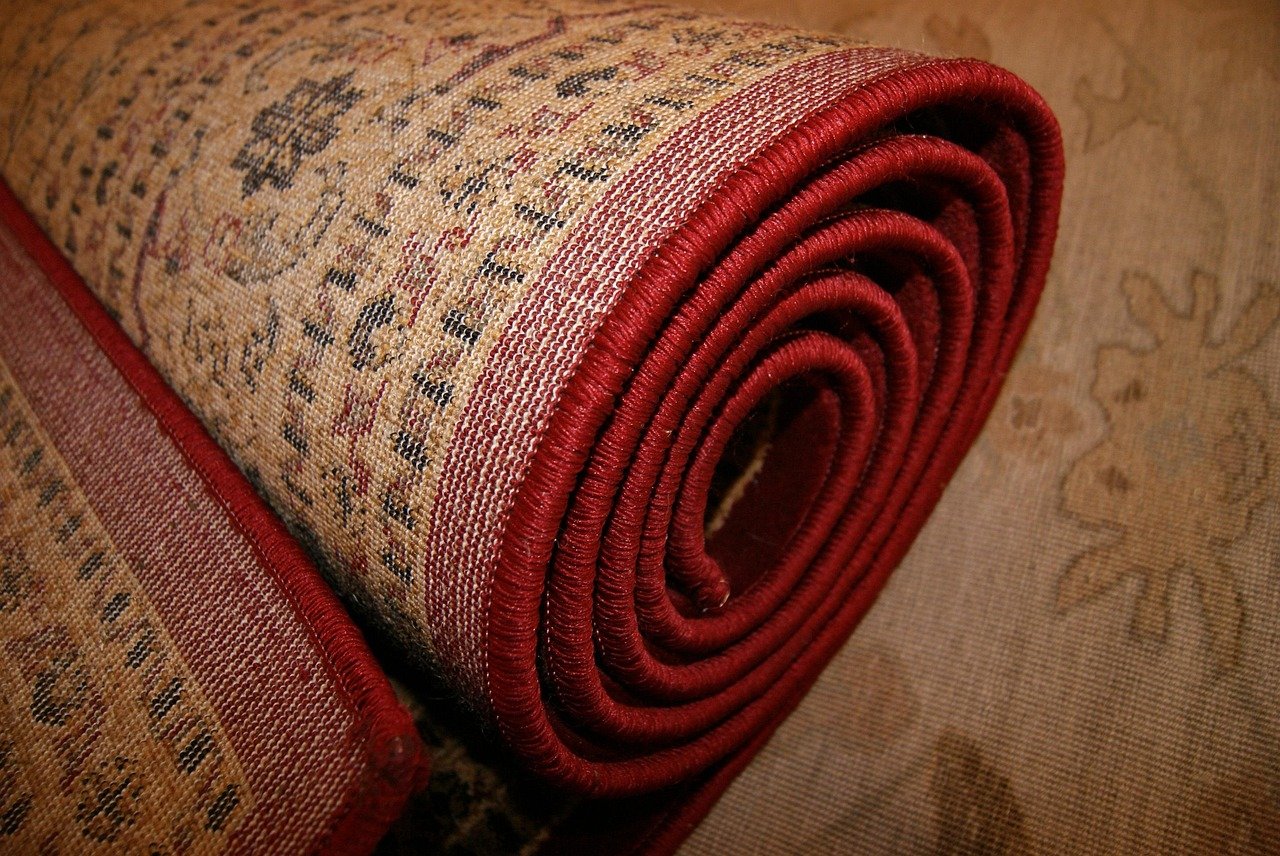 Kashmiri artisan weaving hand-knotted carpet on vertical loom showing intricate silk pattern